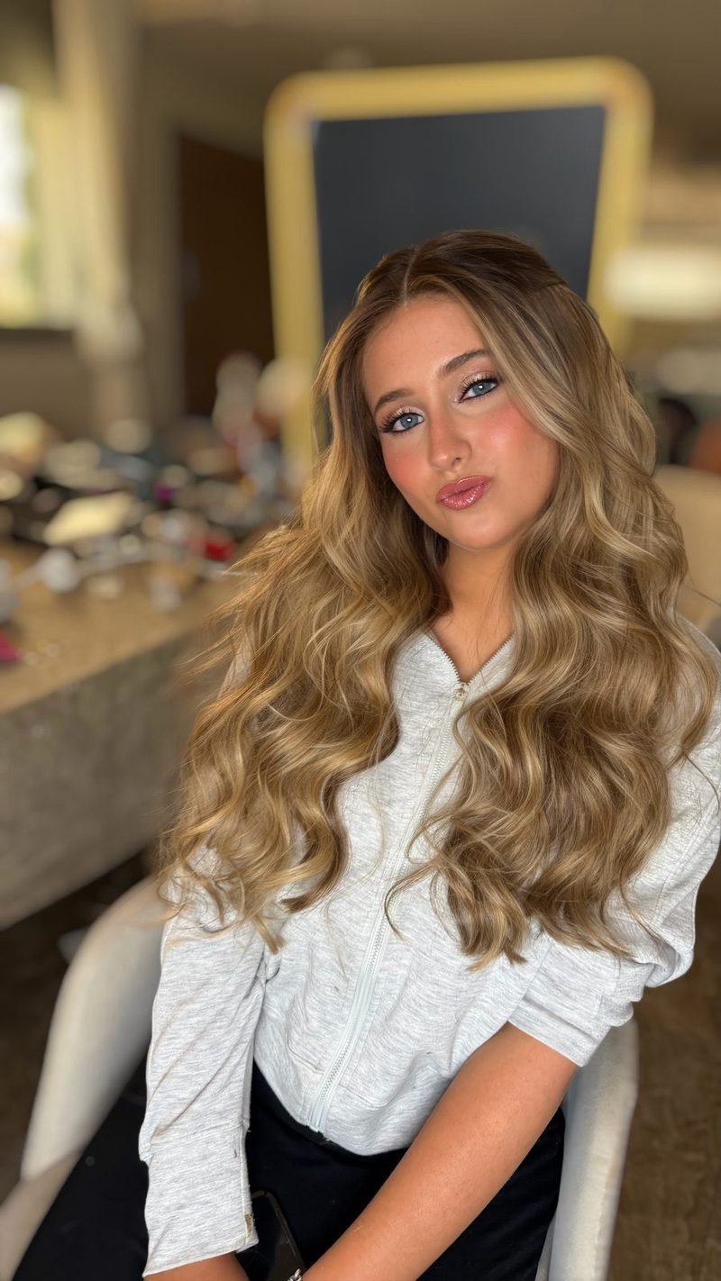 אישה עם שיער בלונדיני גלי ואיפור עיניים מעושן ורך על עור מט ואחיד